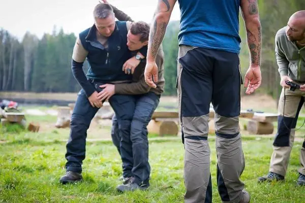 Zwei Personen üben eine Hebetechnik, während zwei weitere zuschauen