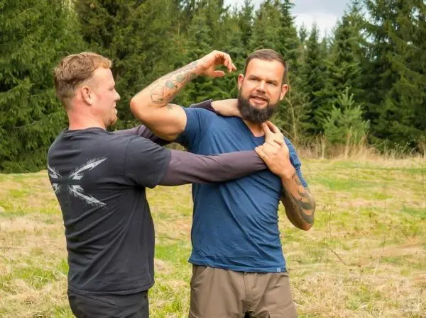 Zwei Personen üben eine Selbstverteidigungstechnik im Freien