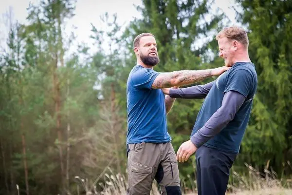 Zwei Personen üben eine Selbstverteidigungstechnik im Freien