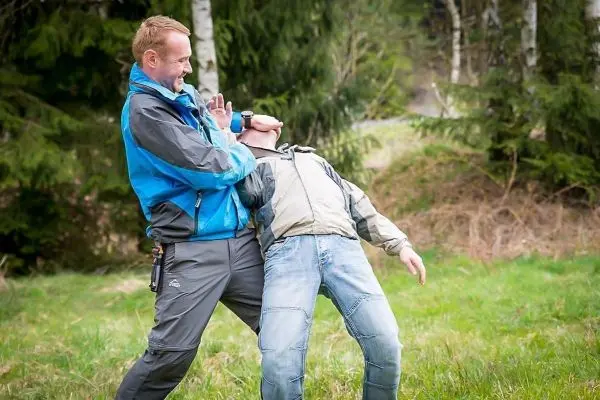 Zwei Personen üben eine Selbstverteidigungstechnik im Freien aus
