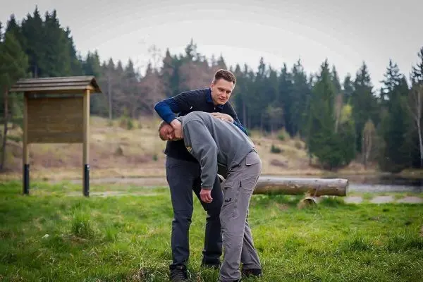 Zwei Personen üben eine Technik zur Unterstützung in einer Outdoor-Umgebung