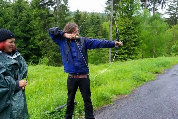 Bogen wird gespannt, während eine Person zuschaut