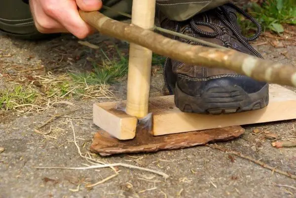 Holzstück mit Kerbe erzeugt durch Reibung Glutnest