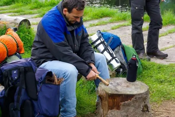 Messer bearbeitet Holzstück auf einem Baumstumpf am Ufer
