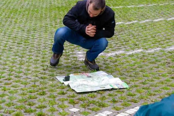 Person kniet vor einer Karte auf dem Boden