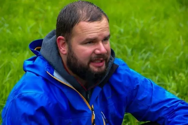 Person sitzt im Gras und spricht