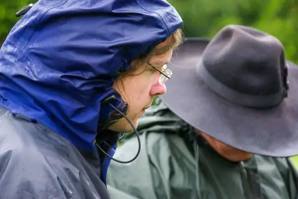Person trägt eine Regenjacke und schaut nach unten