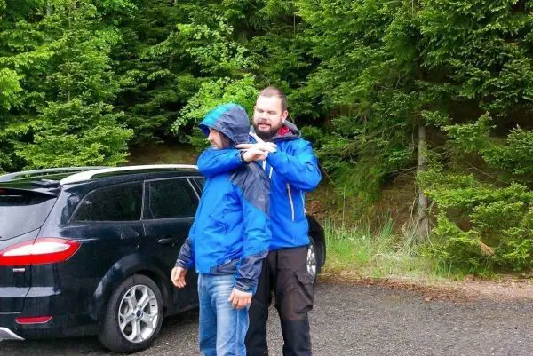 Person zeigt einer anderen Person eine Technik im Freien