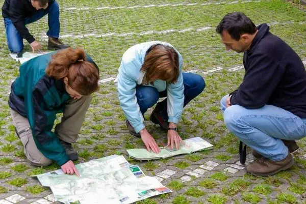 Personen betrachten Karten auf dem Boden beim Überlebenstraining