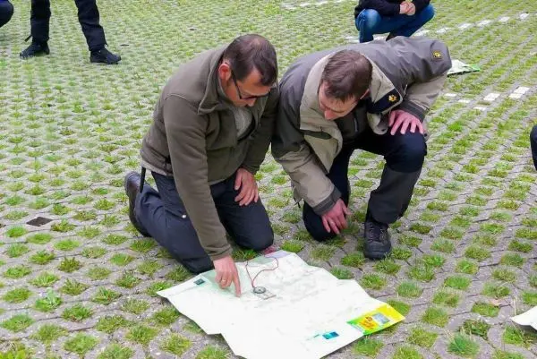 Zwei Personen betrachten eine Karte auf dem Boden