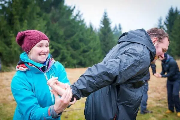 Frau übt eine Technik zur Handbefreiung mit einem Mann im Freien
