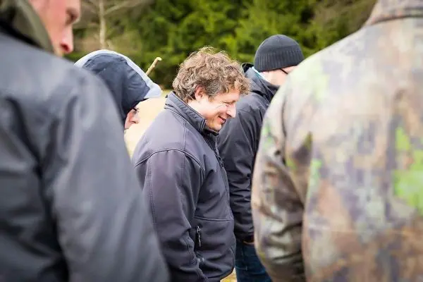 Gruppendiskussion über Technik im Freien, Teilnehmer in wetterfester Kleidung