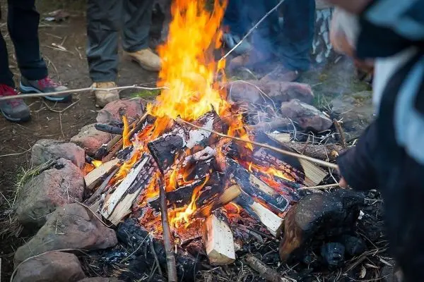 Kleine Flamme in einem Steinkreis, Holzscheite brennen