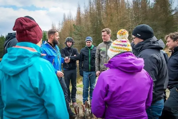 Person erklärt einer Gruppe von Teilnehmern beim Überlebenstraining