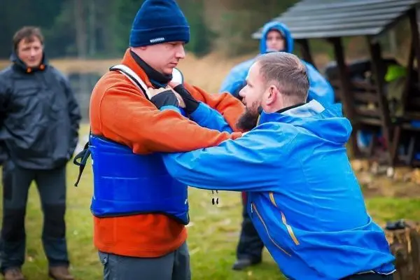 Zwei Personen üben eine Technik mit Schwimmweste im Freien