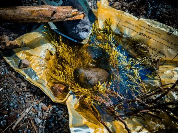 Wasseransammlung mit Steinen und Zweigen in einer gelben Folie