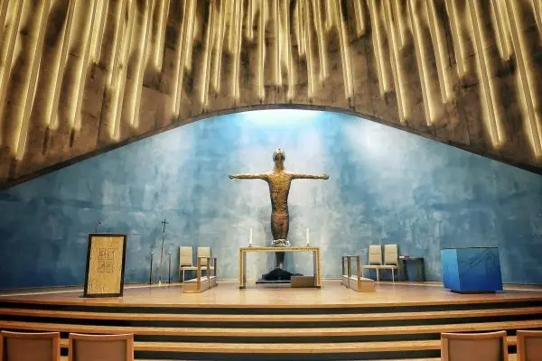 Altar mit Kreuzfigur und Stühlen in einem Innenraum