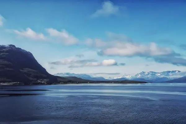 Bergige Küstenlandschaft mit ruhigem Wasser und bewölktem Himmel
