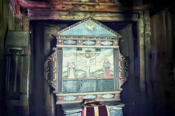 Bunt bemalter Altar mit religiösen Motiven in einem Holzraum