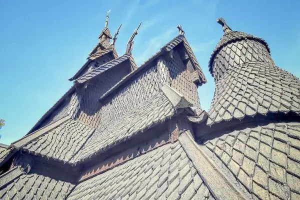 Dach mit Schindeln und Türmchen unter blauem Himmel