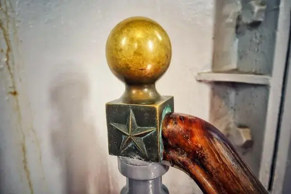 Detailaufnahme eines Griffes mit einer goldenen Kugel und einem Stern auf der Halterung