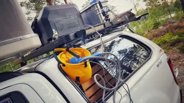 Diverse Ausrüstungsgegenstände auf dem Dach eines Fahrzeugs, darunter ein gelber Behälter und Schläuche