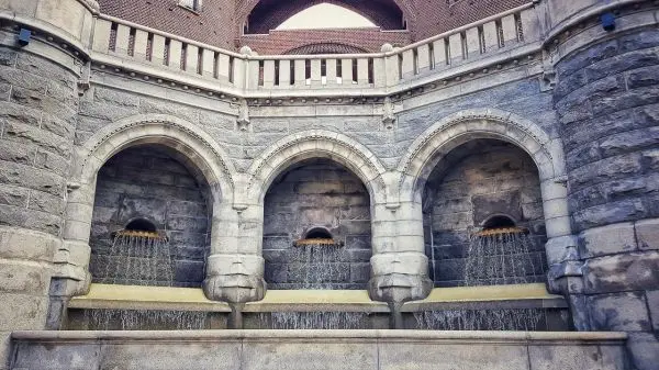 Drei Bögen mit Wasserfällen aus Steinmauerwerk und darunterliegendem Becken