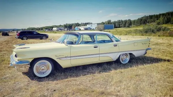 Ein gelbes Oldtimer-Auto steht auf einer Wiese
