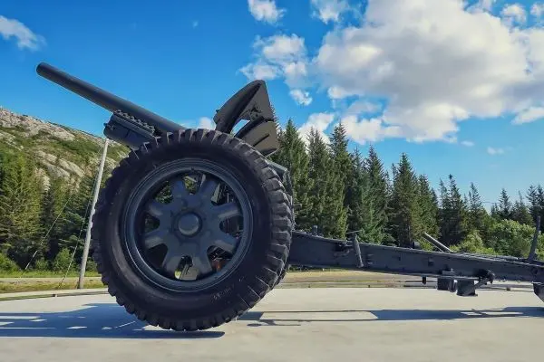 Ein Rad eines Fahrzeugs steht auf einer Fläche mit Bäumen im Hintergrund