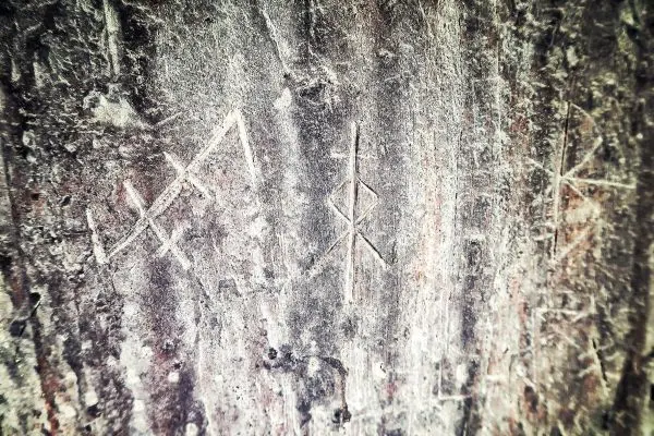 Eingravierte Symbole auf einer rauen Steinoberfläche