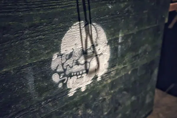 Graue Wand mit einem weißen Totenkopf-Symbol und Schattenwurf