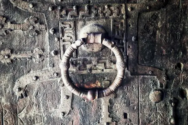 Metallring an einer alten, verzierten Holztür mit eingravierten Mustern