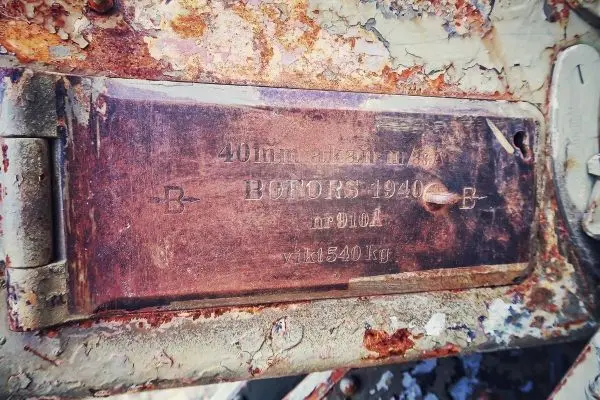 Metallschild mit technischen Daten und Gewichtsinformationen, stark korrodiert