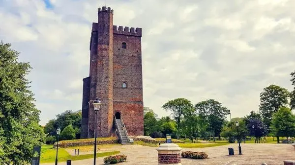 Mittelalterlicher Turm aus Ziegelsteinen mit Treppe und umgebendem Park
