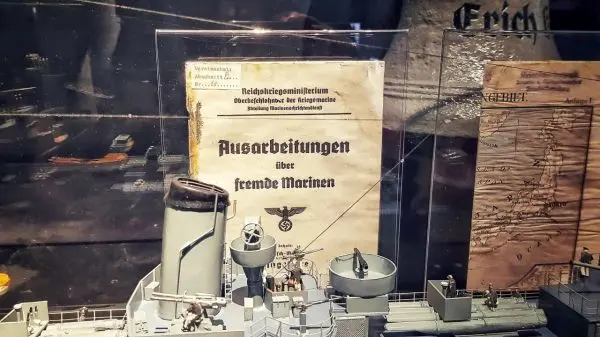 Modell eines Schiffes mit Dokumenten über fremde Marinen im Hintergrund