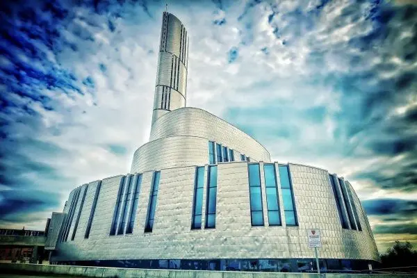 Moderne Architektur mit geschwungener Fassade und hohen Fenstern unter bewölktem Himmel