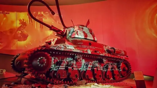 Panzer mit Kettenantrieb und auffälliger Lackierung in einem Ausstellungsraum