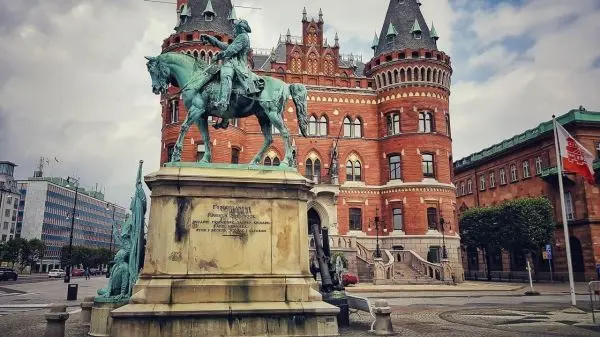 Reiterstatue vor historischer Backsteinarchitektur mit Türmen und Fenstern