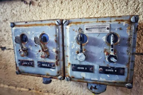 Rostige Schaltkästen mit Hebeln an einer Wand montiert