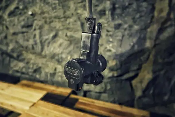 Schalter hängt an einem Kabel vor einer steinernen Wand