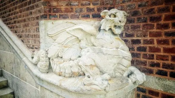 Skulptur eines geflügelten Löwen auf einer Treppenstufe aus Stein