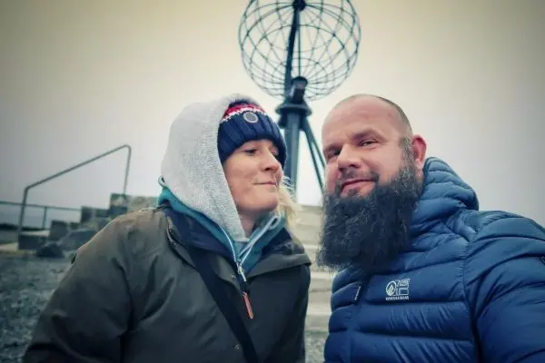 Zwei Personen stehen vor einem Globus auf einem Sockel