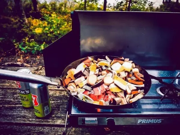 Pfanne mit buntem Gemüse auf einem Gaskocher im Freien