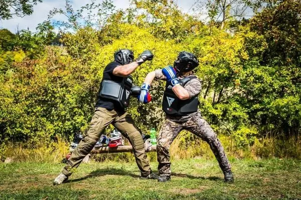 Zwei Kämpfer in Schutzausrüstung führen einen Boxkampf im Freien durch
