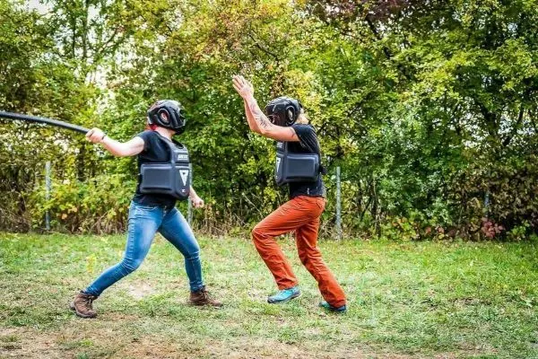 Zwei Personen in Schutzausrüstung üben mit einem Stock in einer Trainingssituation