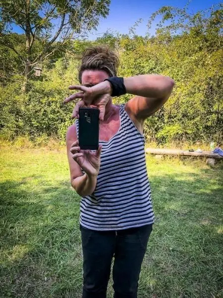 Person hält Smartphone vor sich und posiert für ein Foto