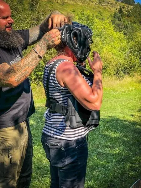 Person setzt einer anderen Person eine Maske auf