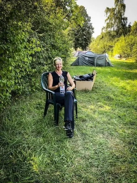 Person sitzt auf einem Stuhl und hält eine Wasserflasche