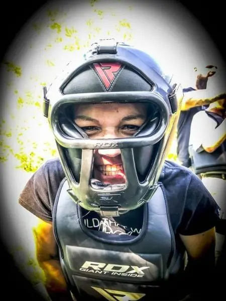 Person trägt einen Schutzhelm und eine Schutzausrüstung, zeigt entschlossene Mimik