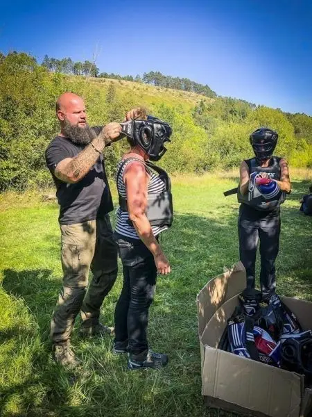 Person trägt Schutzausrüstung, während eine andere Person den Helm anpasst